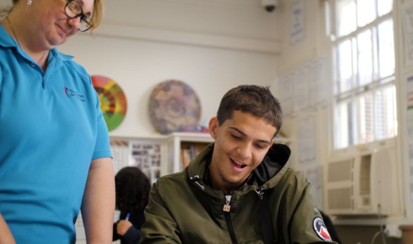 Woman at youth futures community hub standing next to a student