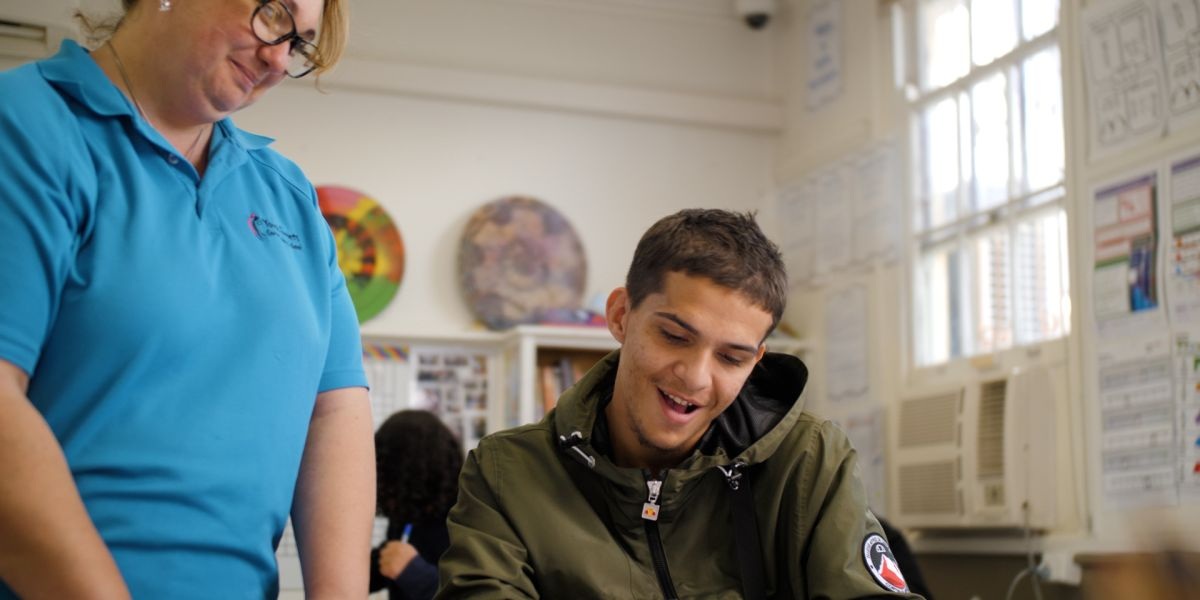 Woman at youth futures community hub standing next to a student