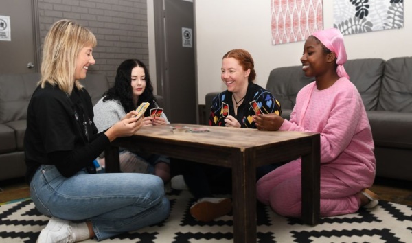 Four women sitting around a table playing uno