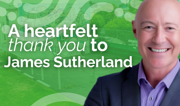 Picture of James Sutherland in front of green banner