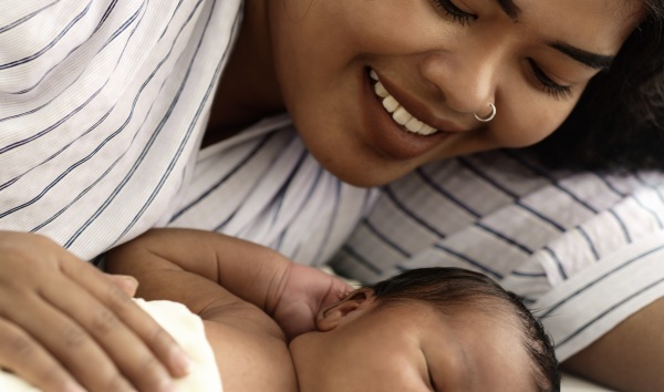 mixed race mother african american and asian watching newborn infant